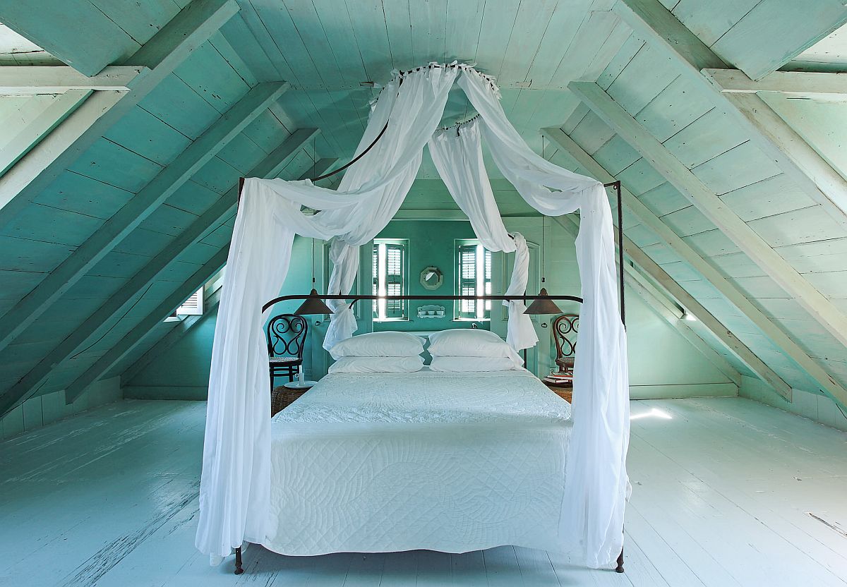 Phòng ngủ gác mái đẹp mộng mơ với những bức tường và sàn màu xanh pastel tạo ra một phông nền đơn sắc đầy mê hoặc.