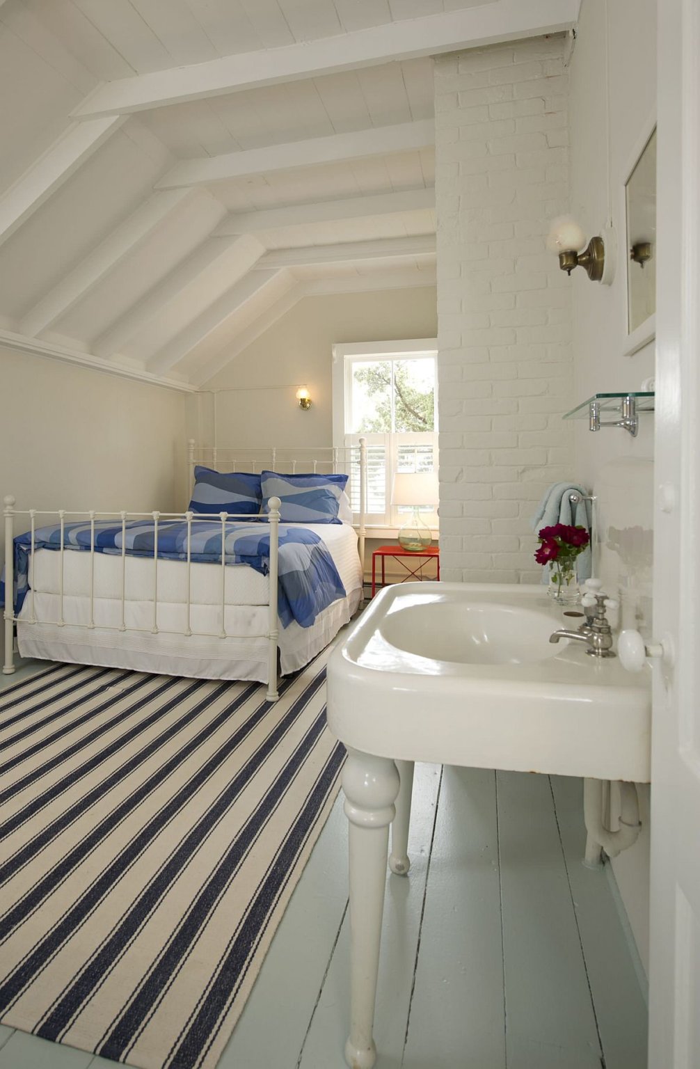hình ảnh phòng ngủ phong cách bãi biển thanh lịch với sàn nhà sơn màu xanh nhạt, thảm trải kẻ sọc