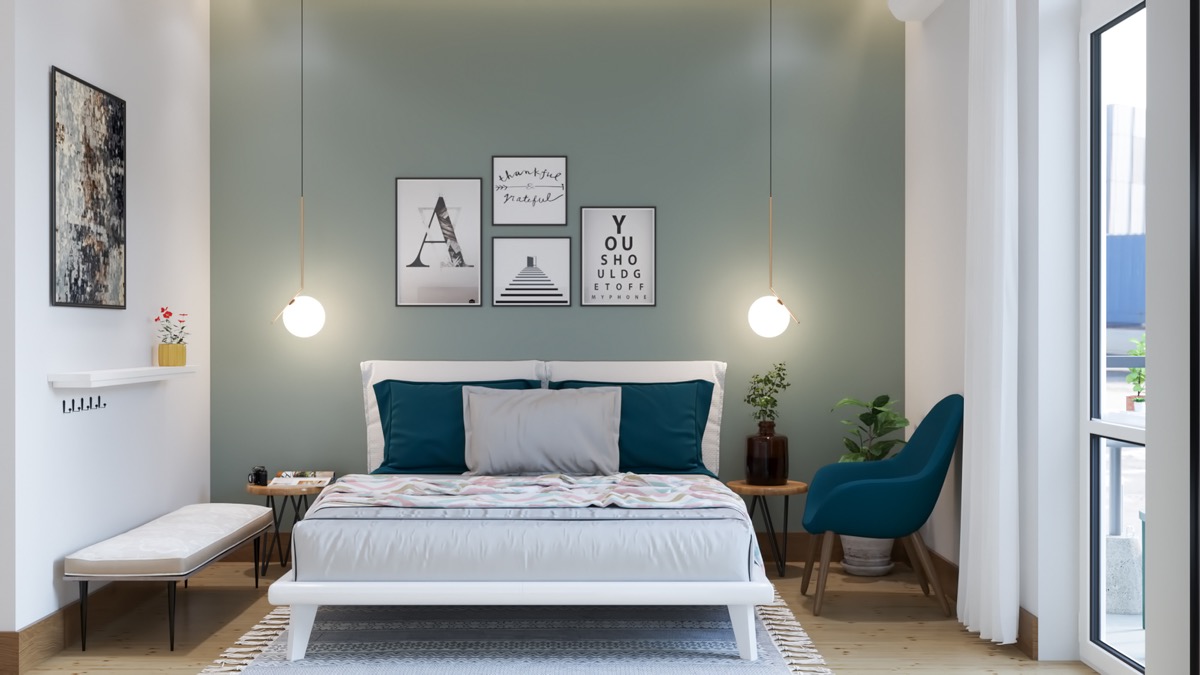 hình ảnh phòng ngủ nhỏ thoáng sáng với tường đầu giường sơn màu xanh lá, bộ tranh treo tường, đèn thả đối xứng, ghế thư giãn màu xanh dương
