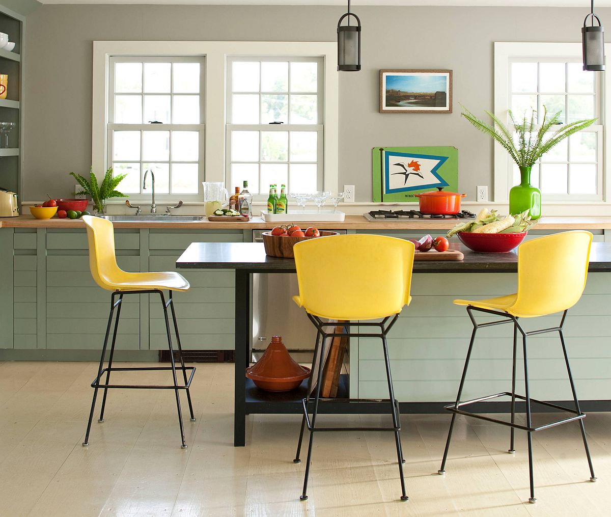 hình ảnh phòng bếp mùa hè thoáng sáng với điểm nhấn là bộ ghế ăn màu vàng chanh, bình cây màu xanh lá