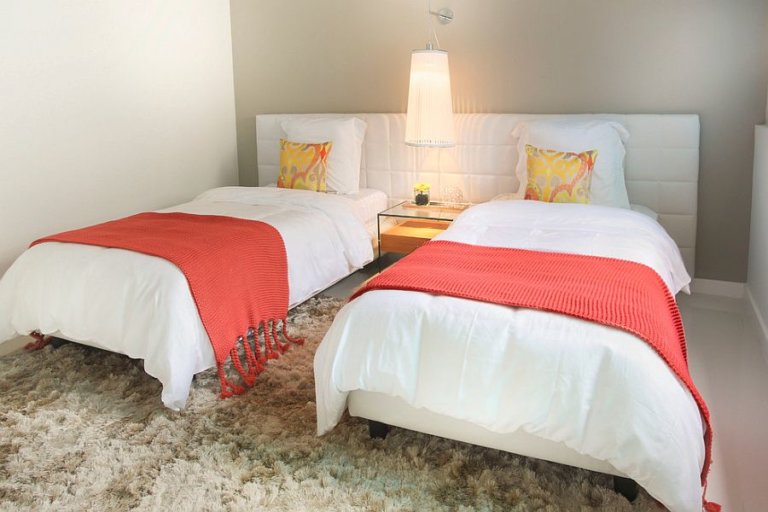 hình ảnh phòng ngủ với giường đôi, chăn màu cam đất, tường đầu giường màu xám