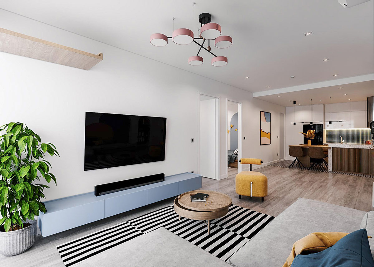 hình ảnh phòng khách căn hộ với thảm trải kẻ sọc đen trắng, bàn trà gỗ hình tròn, kệ tivi màu xanh dương, chậu cây cảnh lớn ở góc phòng