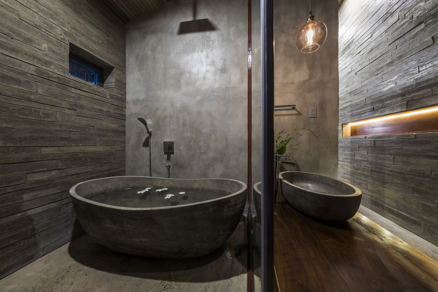 hình ảnh phòng tắm với bồn tắm xi măng, tường ốp gỗ, vách kính trong suốt