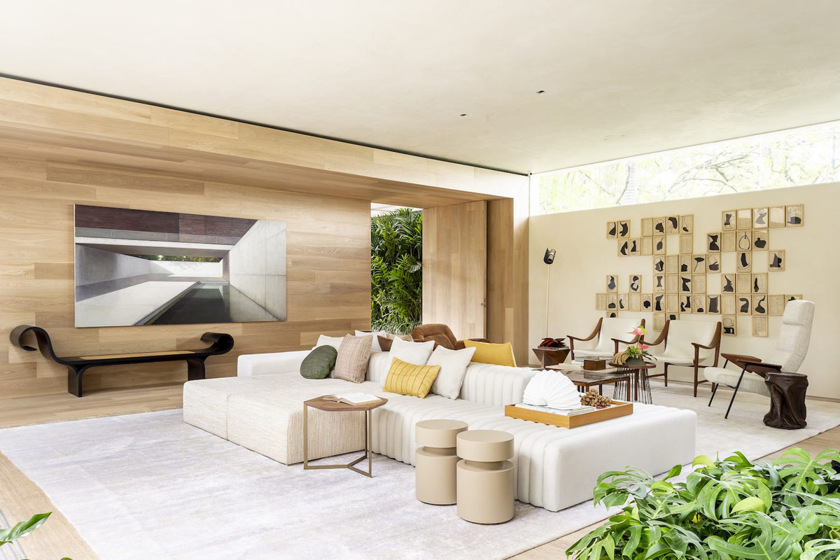 hình ảnh không gian sinh hoạt chung rộng thoáng bên trong nhà vườn nổi bật với bộ ghế sofa màu trắng đặt trên thảm trải lớn cùng tông màu