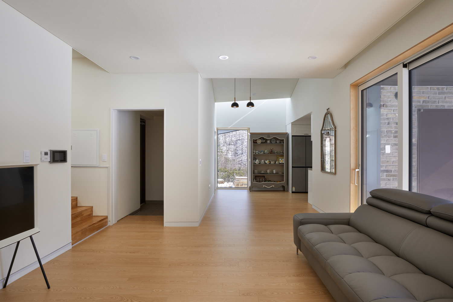 hình ảnh phòng khách nhà mái dốc với sàn lát gỗ, sofa màu ghi xám