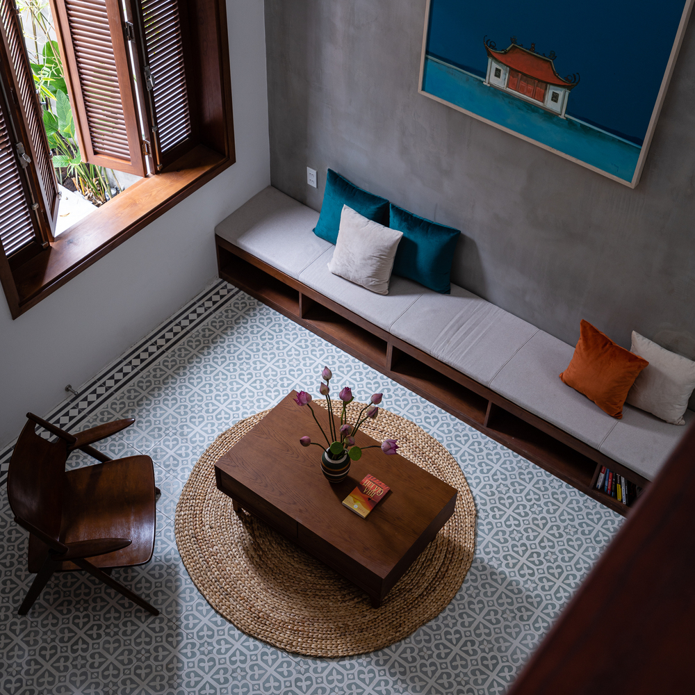 hình ảnh phòng  khách nhà phố đẹp với băng ghế gỗ gắn tường, bàn trà gỗ, ghế bành thư giãn, cửa sổ mở ra sân vườn