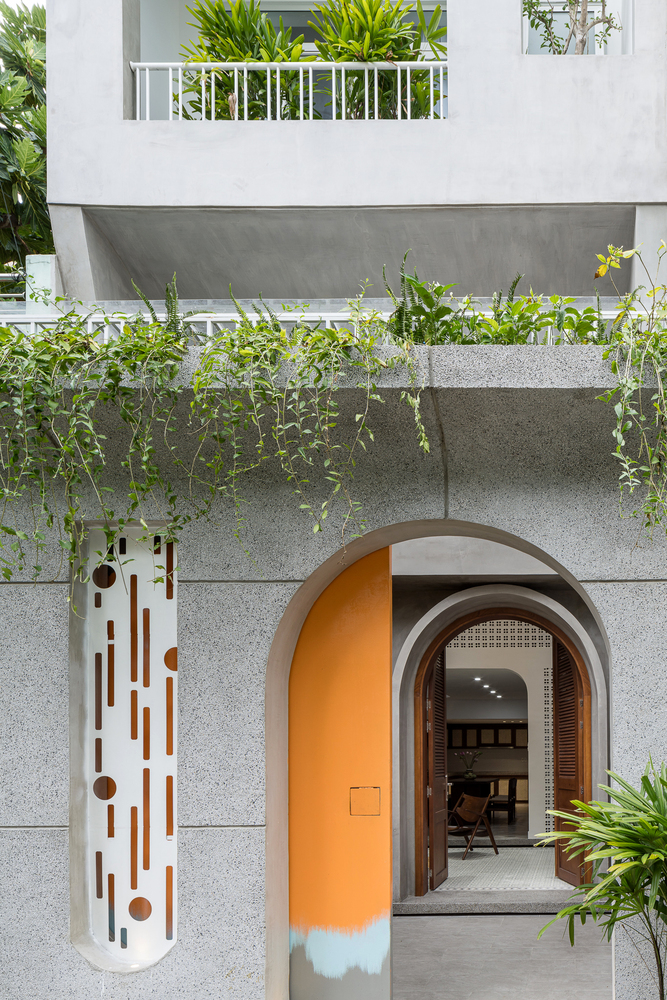 hình ảnh lối vào nhà phố đẹp với khung cửa vòm màu vàng, cây xanh nhấn nhá