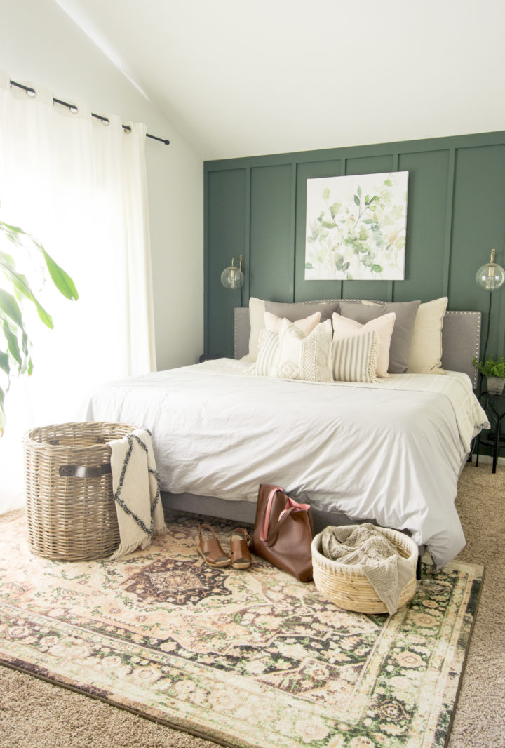 hình ảnh phòng ngủ hiện đại với tường đầu giường sơn màu xanh lá, thảm trải thổ cẩm, giỏ mây cuối giường