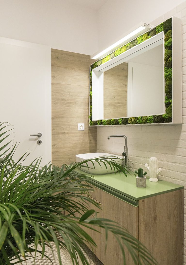 hình ảnh phòng tắm nhỏ gọn với mặt bàn màu xanh cùng tông với cây trồng trong nhà