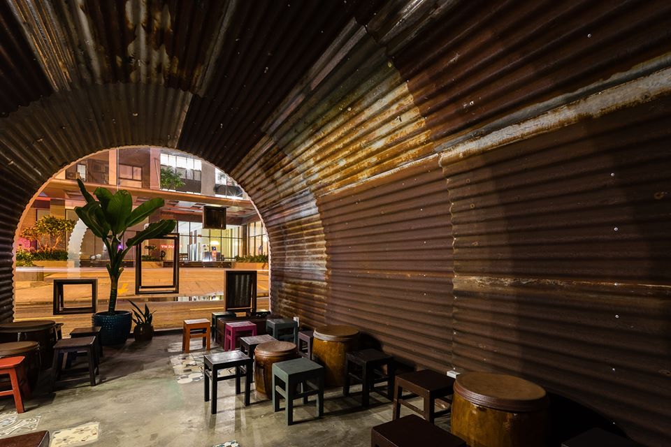 hình ảnh không gian bên trong quán cà phê Bông ở Sài Gòn với trần vòm ốp tôn, bàn ghế gỗ mộc