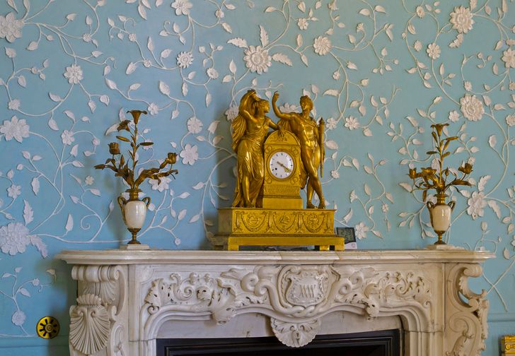 hình ảnh lối vào nhà với tường dán giấy màu xanh dương, họa tiết hoa n ổi, tượng phù mạ vàng sáng bóng
