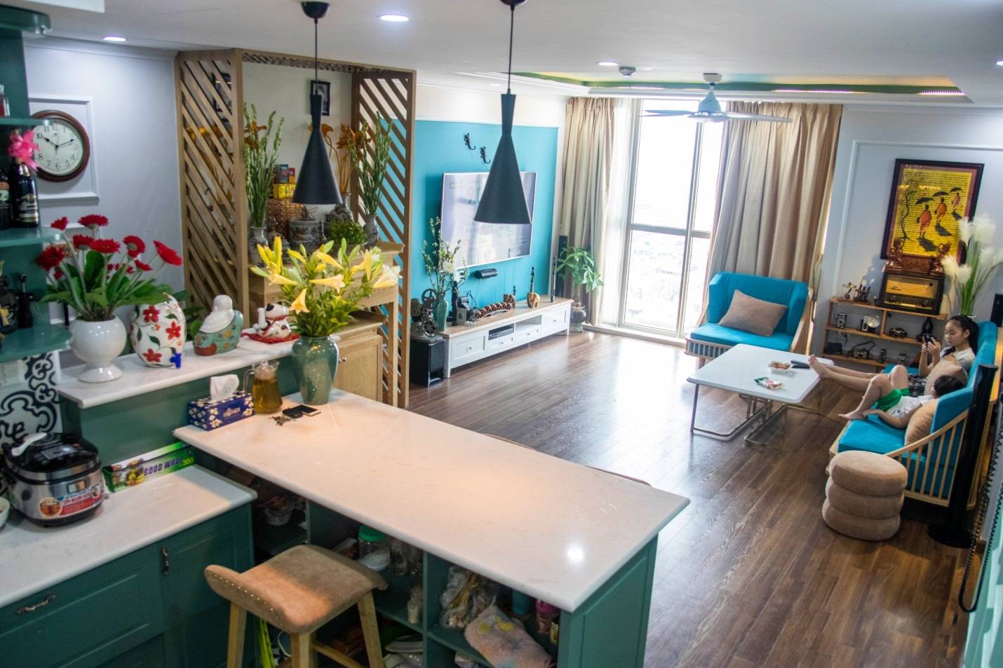 hình ảnh toàn cảnh phòng khách căn hộ màu xanh liên thông với khu bếp