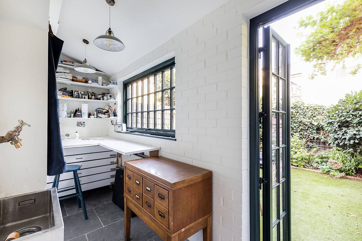 hình ảnh không gian trống cạnh phòng bếp kiêm góc thủ công với tường gạch lộ sơn trắng, sân vườn xanh mát