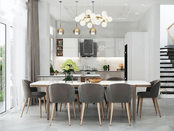 hình ảnh mẫu phòng bếp kết hợp phòng ăn được thiết kế với tông màu trung tính chủ đạo với điểm nhấn là bộ đèn thả mặt dây chuyền sáng bóng.
