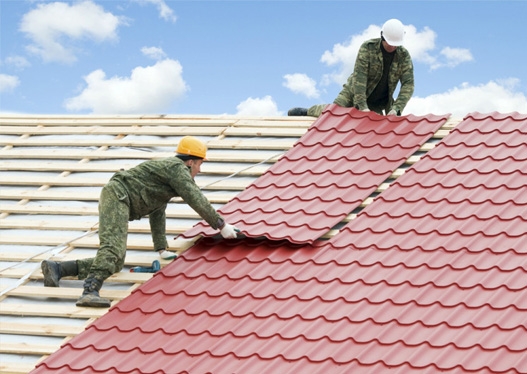 hình ảnh hai người thợ đang thi công lắp mái tôn giả ngói cho nhà ở
