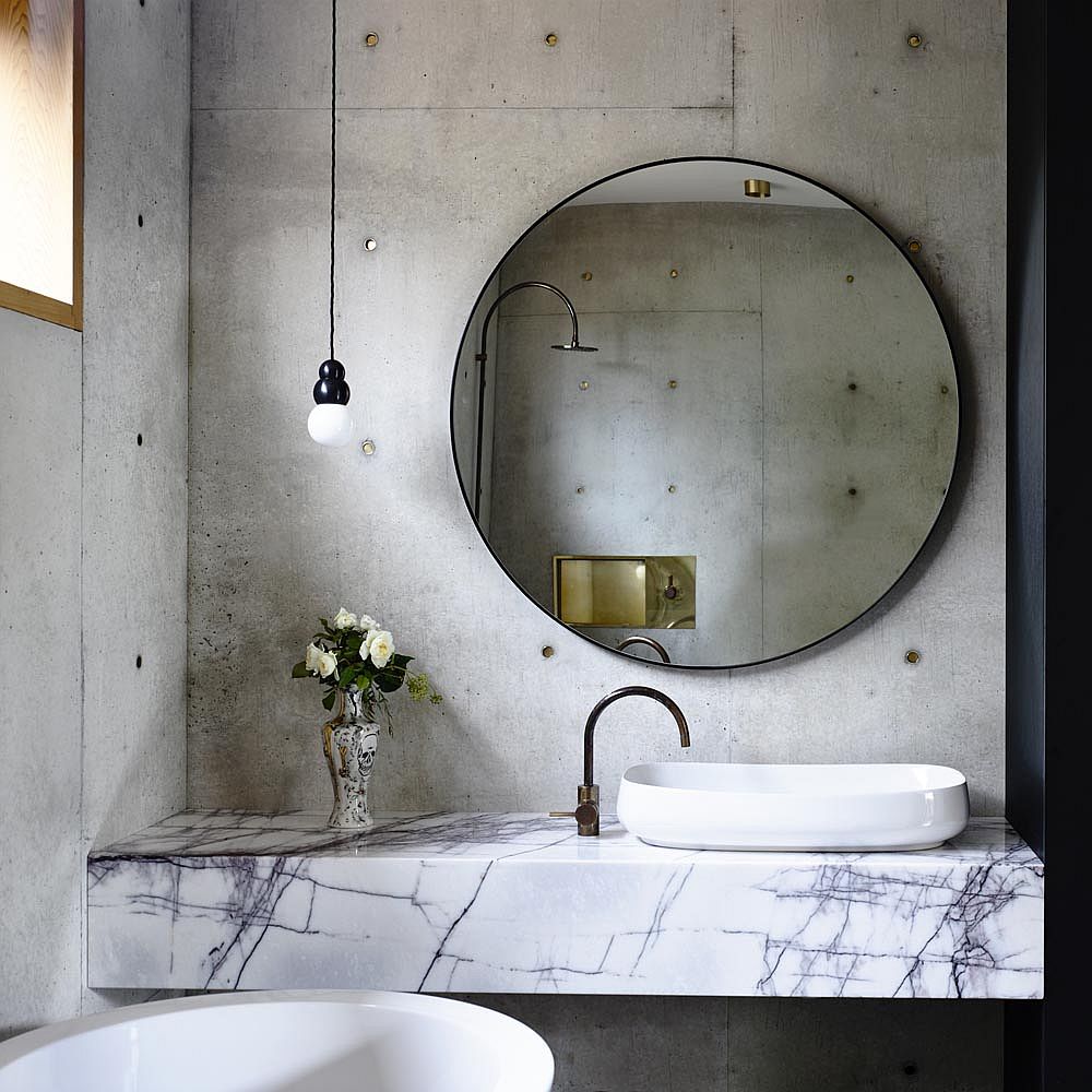 Bệ bồn rửa bằng đá cẩm thạch trong phòng tắm ngôi nhà bê tông tạo ra sự tương phản  trực quan ấn tượng.