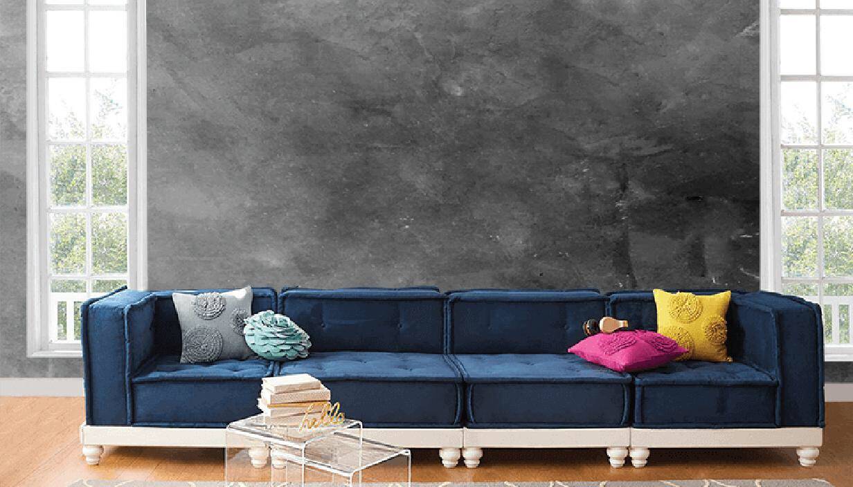 Ghế sofa màu xanh dương, gối tựa màu sắc rực rỡ nổi bật trên nền tường bê tông xám.