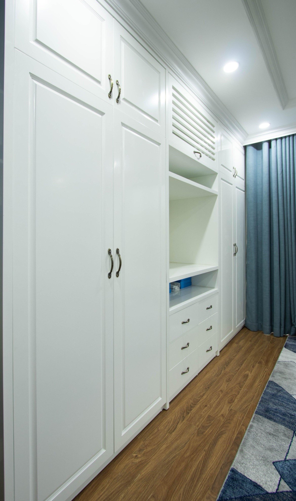 Hệ tủ màu trắng cao kịch trần cung cấp không gian lưu trữ thoải mái, đồng thời tạo cảm giác thoáng đãng hơn.