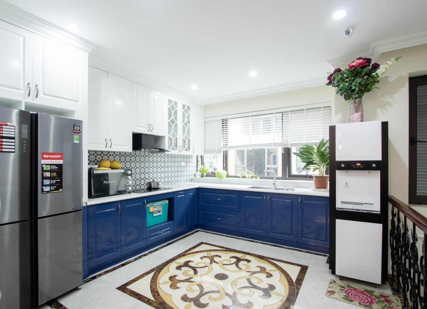 Phòng bếp chữ L thoáng rộng với sự kết hợp hoàn hảo giữa sắc xanh dương và trắng tinh khôi.