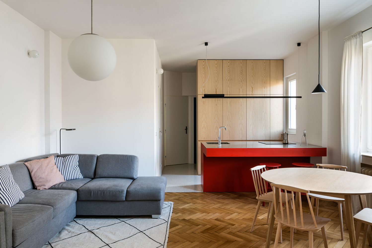 Trong căn hộ 20m2, phòng khách, bếp và khu vực ăn uống nằm trong cùng một không gian mở liên thông nhưng vẫn có sự tách biệt nhất định nhờ màu sắc nội thất.