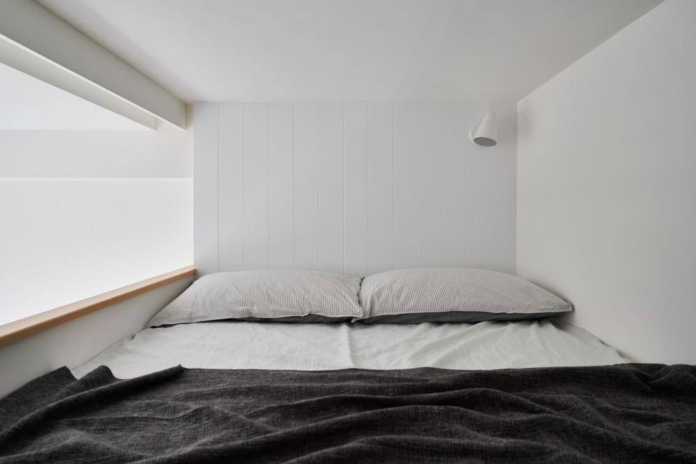 Phòng ngủ riêng tư, yên tĩnh trên gác lửng với thiết kế nội thất tối giản, hiện đại.