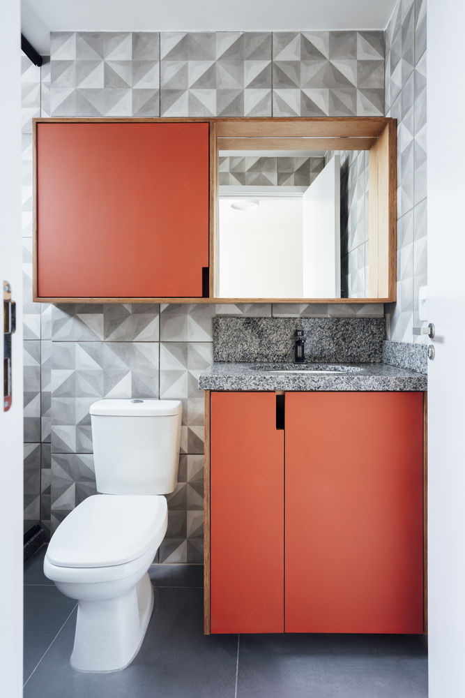 Phòng vệ sinh ấn tượng với tủ lưu trữ màu đỏ cam nổi bật.