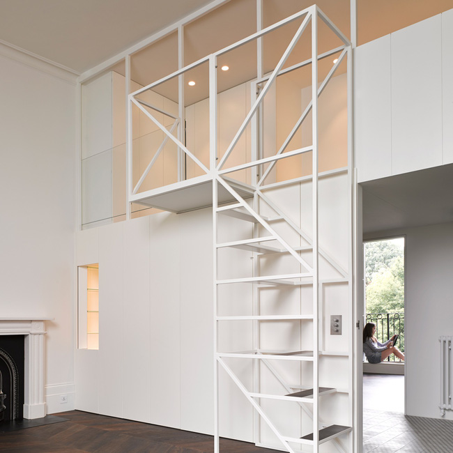 Cầu thang bằng kim loại sơn trắng như hòa lẫn vào phông nền chung, tạo cảm giác rộng thoáng hơn cho không gian nhà nhỏ.