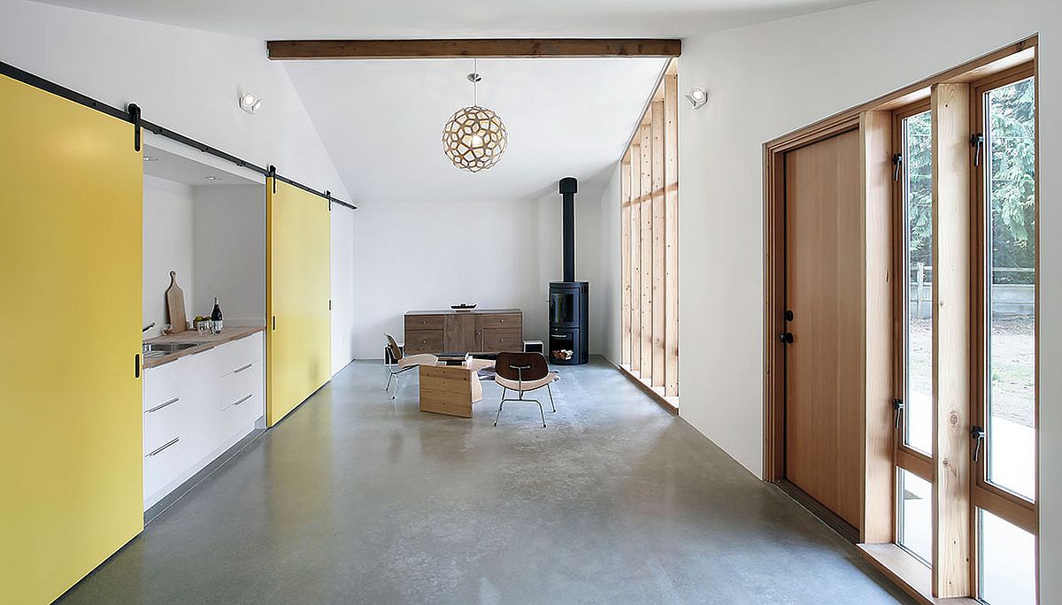 Hệ cửa phong cách Mid-century mang đến sự thông thoáng cho nhà phụ, trong khi cửa lùa màu vàng che khuất phòng ngủ và không gian riêng tư bên cạnh