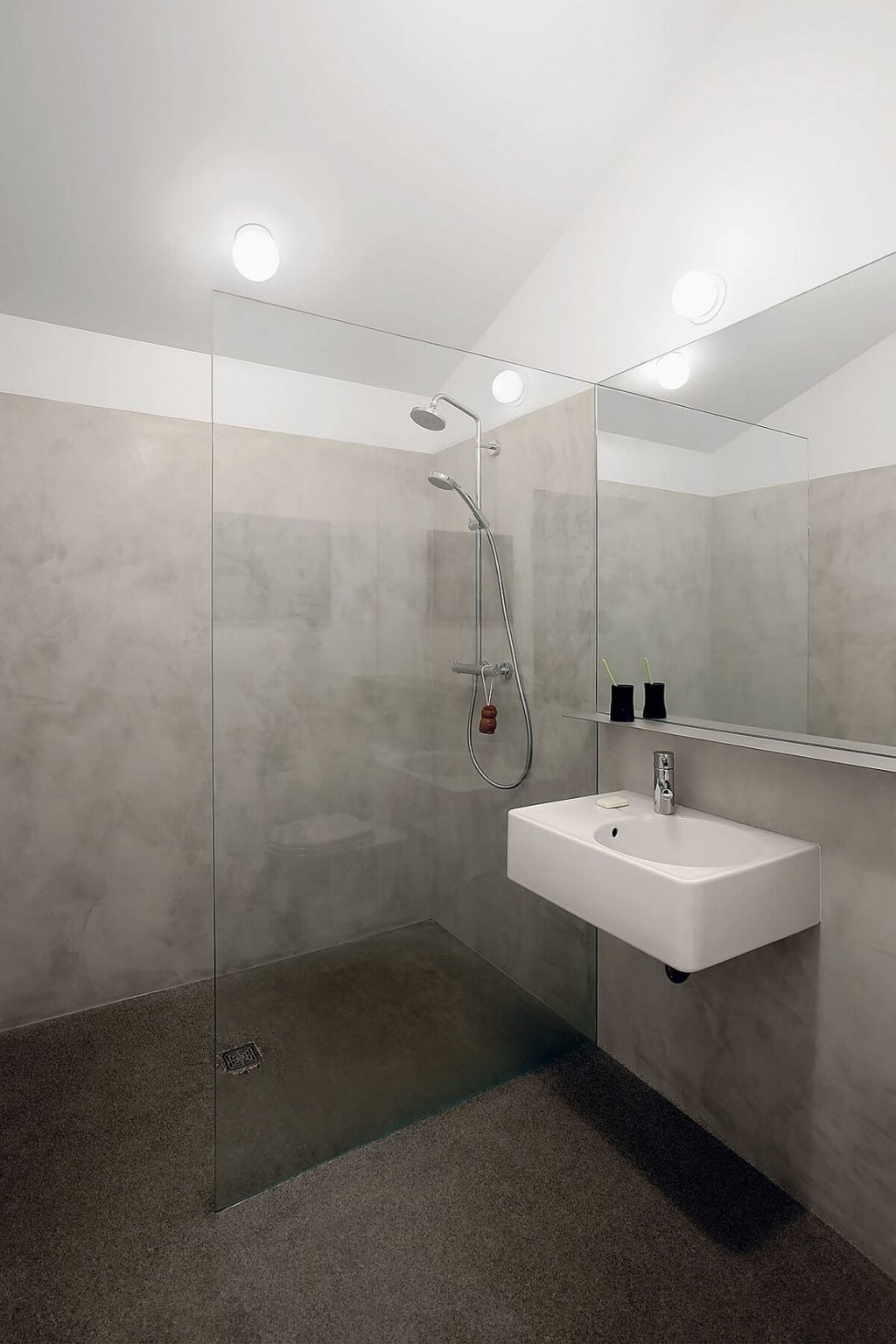 Phòng tắm, khu vực vệ sinh trong nhà phụ được thiết kế và bài trí theo phong cách hiện đại, tối giản với tông màu xám trắng chủ đạo.