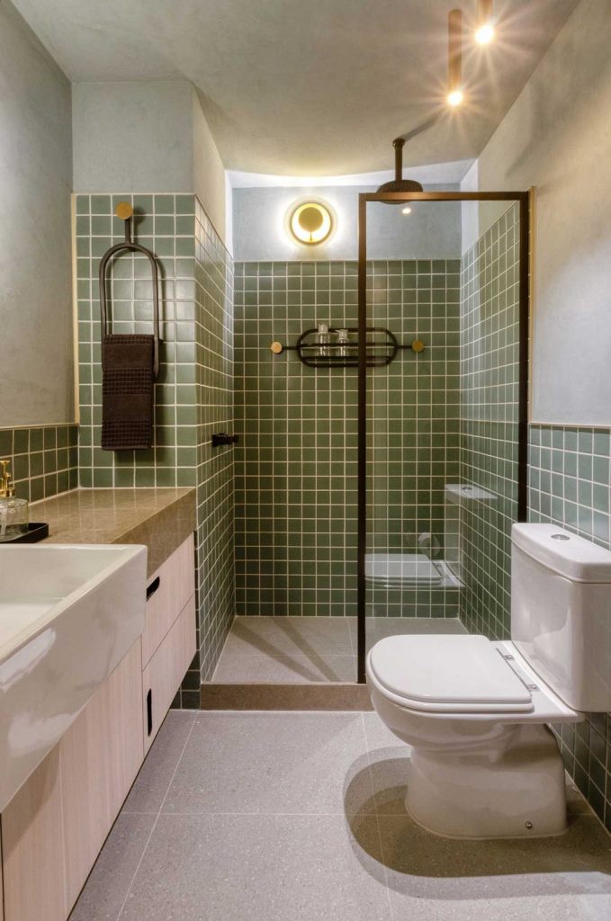 Phòng tắm phong cách hiện đại giữa thế kỷ với gạch màu xanh lá cây nổi bật trên phông nền màu trung tính chủ đạo.