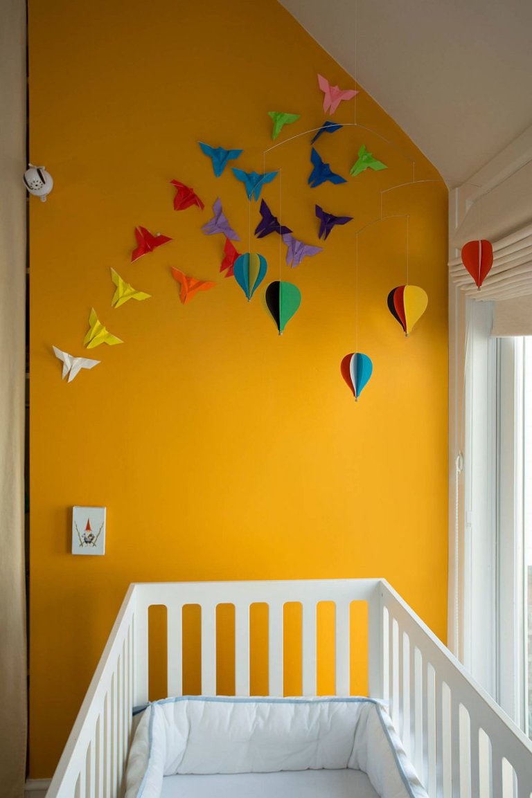 góc phòng ngủ của trẻ với bức tường màu vàng cam ấn tượng