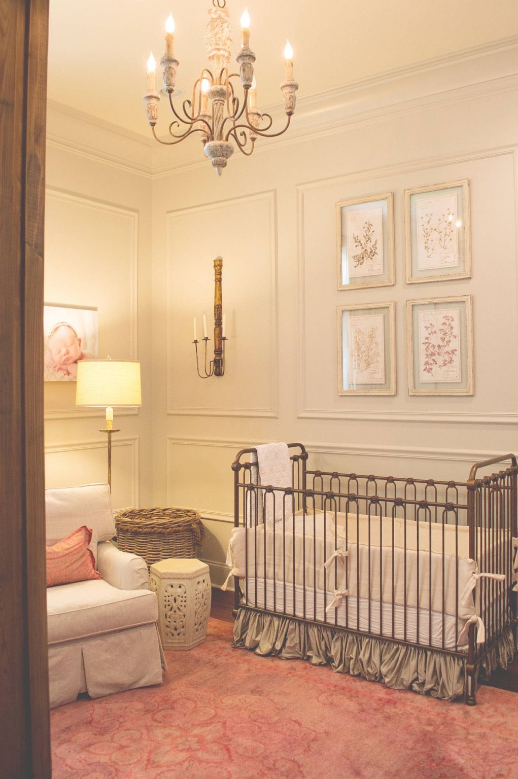 Những điểm nhấn màu hồng cam nhạt và tấm thảm tạo thêm nét duyên dáng, đáng yêu trong phòng cho trẻ sơ sinh này.