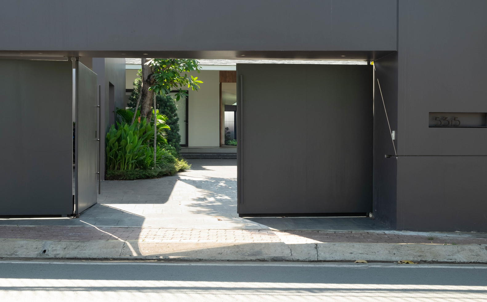 Hệ cửa dẫn lối vào nhà có thiết kế đơn giản với sắc xám thanh lịch, hiện đại.