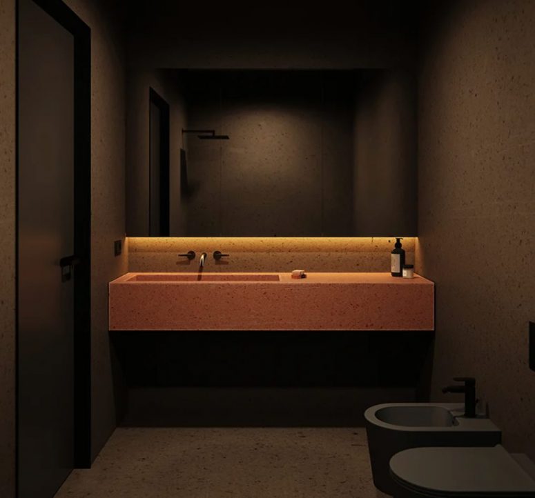 Phòng tắm tạo ấn tượng thị giác mạnh bởi sự tương phản giữa bồn rửa xi măng màu đỏ và phông nền tổng thể màu đen.