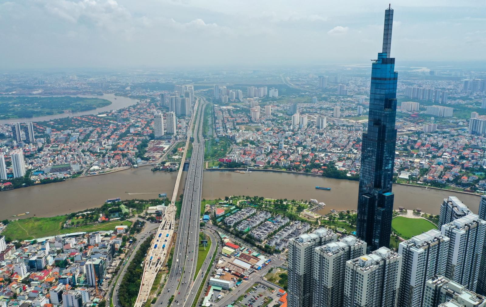 hình ảnh một góc TP.HCM nhìn từ trên cao vói nhiều tòa nhà cao tầng xen kẽ khu dân cư thấp tầng, cây xanh, sông nước