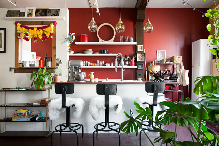 phòng bếp ấn tượng với mảng tường sơn màu đỏ gạch, ghế bar phủ nệm lông trắng muốt