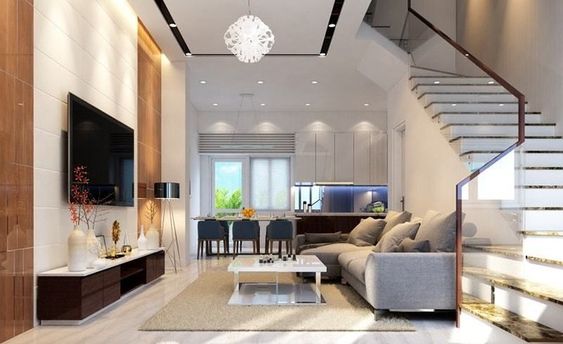 Phòng khách được thiết kế và bài trí đơn giản, gọn đẹp với bộ sofa màu ghi xám, bàn trà cùng tông với kệ tivi đối diện.