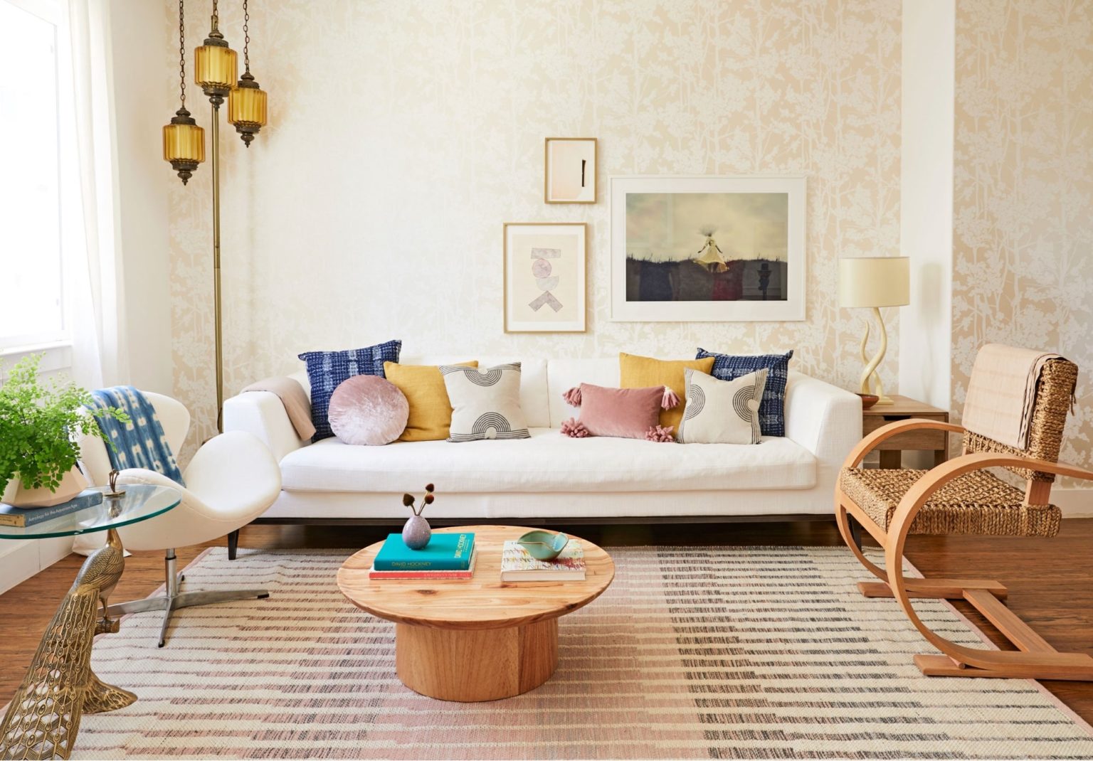 hình ảnh phòng khách phong cách Bohemian với sofa màu trắng, bàn trà tròn, ghế mây nhẹ nhàng, đèn thảm màu vàng ấm áp