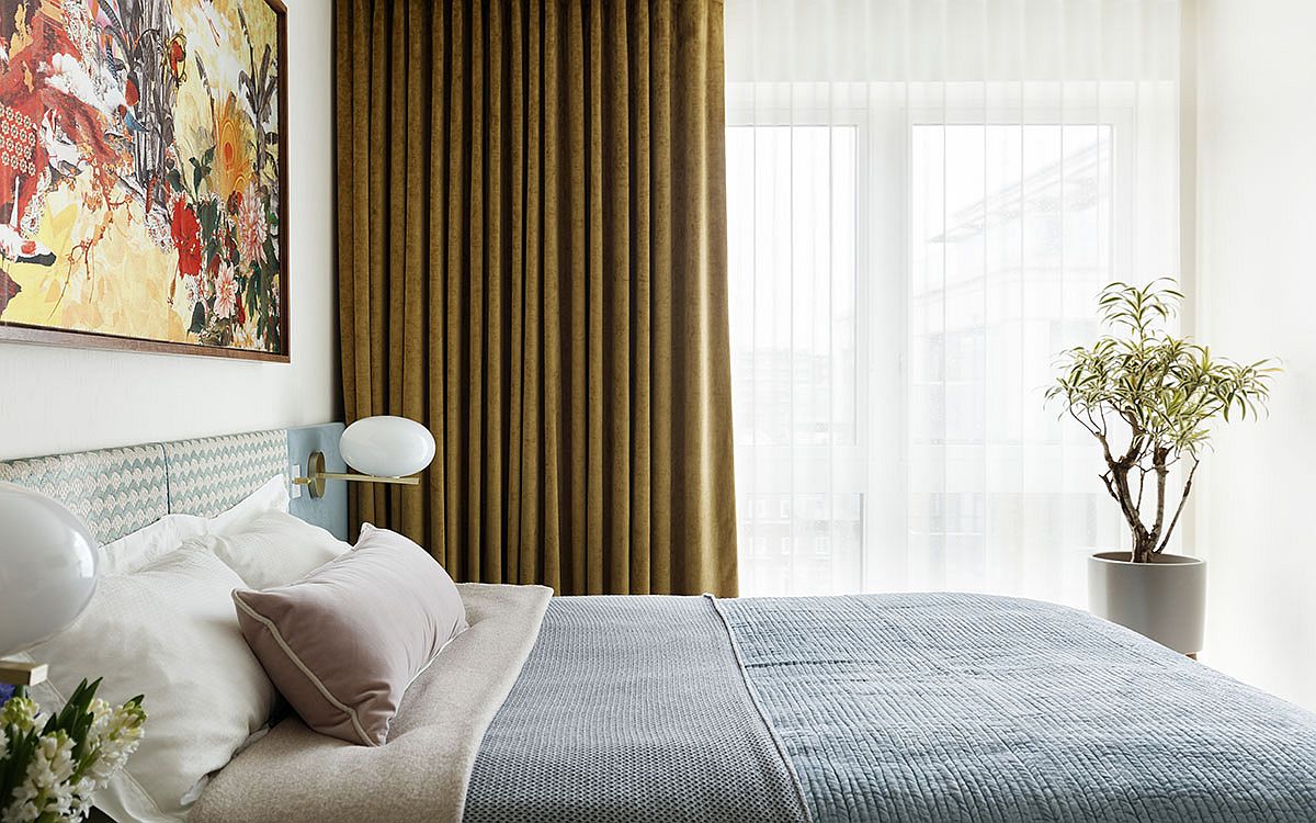Trang trí phòng ngủ màu trắng hiện đại với nghệ thuật treo tường màu sắc, cây trồng trong nhà và các điểm nhấn khác từ rèm cửa, đèn tường.
