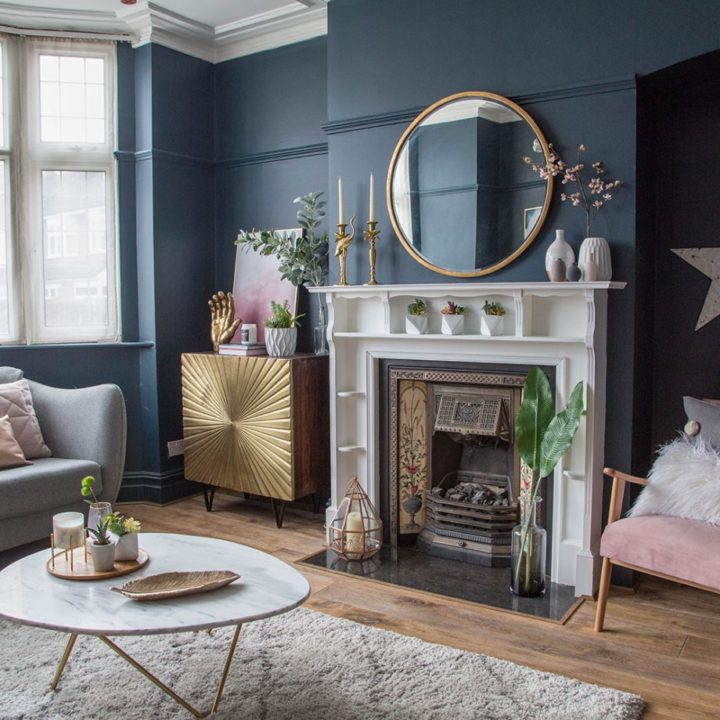 góc phòng khách với lò sưởi, bàn trà gỗ, thảm trải, sơn tường màu xanh lam