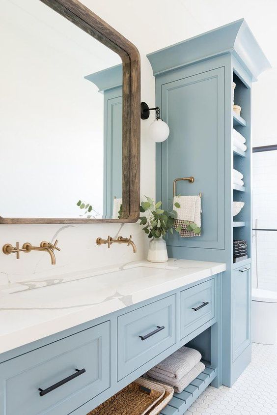 Tích hợp cùng tủ ngăn kéo dưới bồn rửa mặt, kệ góc màu xanh dương tạo điểm nhấn dịu mát, nhẹ nhàng cho phòng tắm hiện đại.
