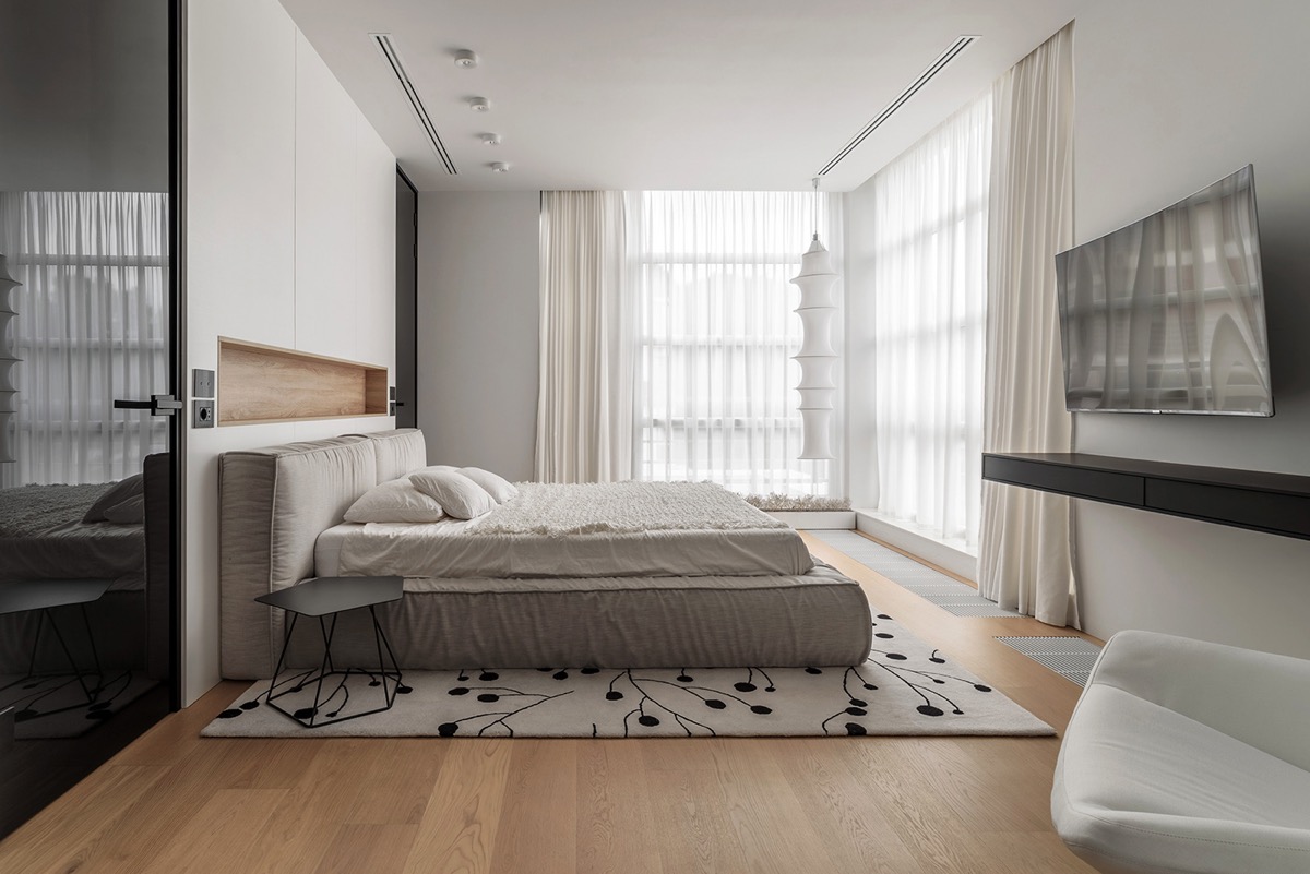 Phòng ngủ master được bài trí theo phong cách tối giản, nhẹ nhàng. Điểm nhấn là chiếc giường màu xám nằm trên tấm thảm có hoa văn và rèm cửa hai lớp. 