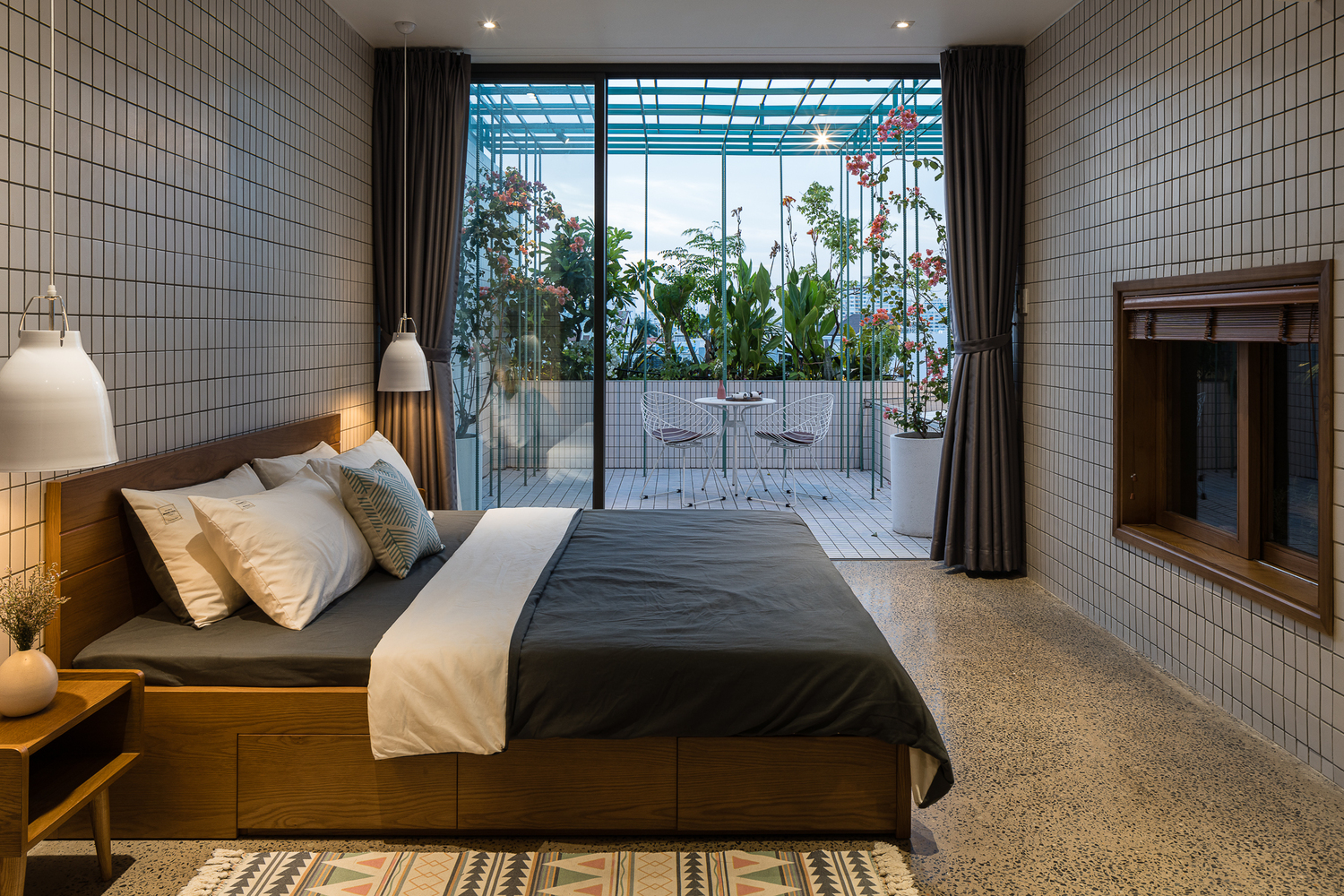 Phòng ngủ căn hộ ở tầng trên cùng có cửa kính trượt mở ra góc thư giãn lý tưởng nơi ban công, sân thượng nhà phố.