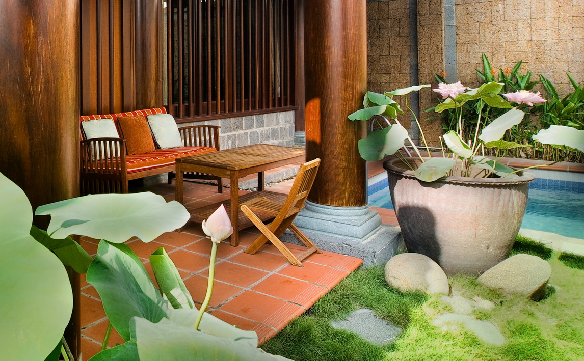 góc thư giãn nơi hiên nhà với bàn ghế gỗ, tiểu cảnh cây xanh, sân vườn