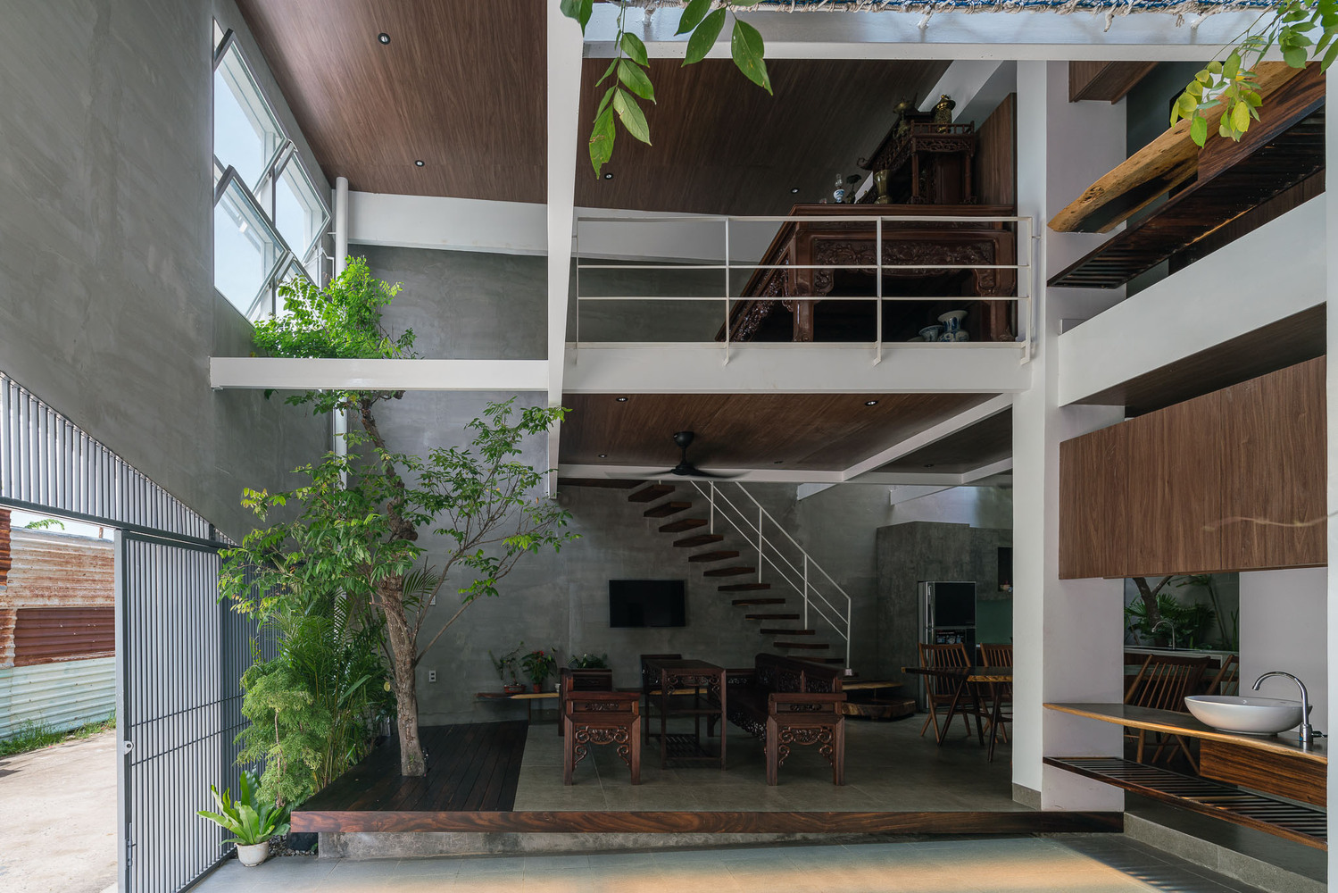 không gian bên trong nhà với nội thất gỗ ấm áp, tường xi măng, cây xanh tốt