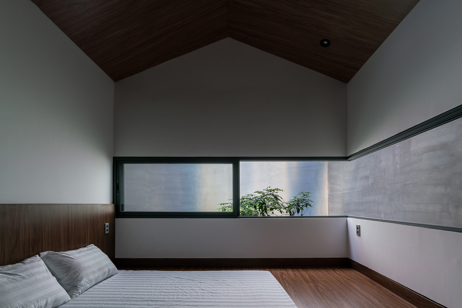 phòng ngủ tối giản với giường bệt, cửa sổ kính, trần ốp gỗ