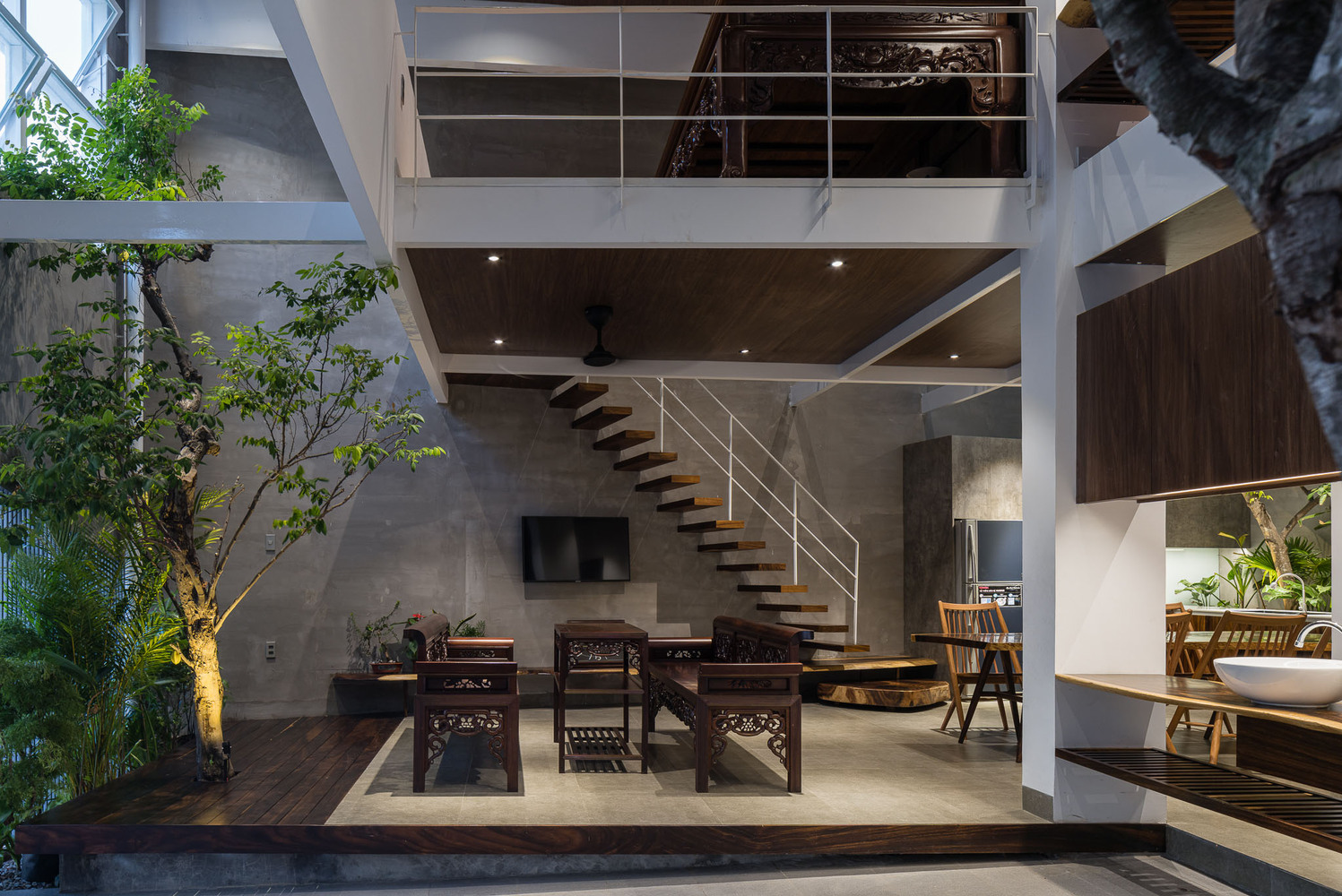 không gian bên trong nhà 2 tầng với cây xanh, nội thất gỗ ấm cúng