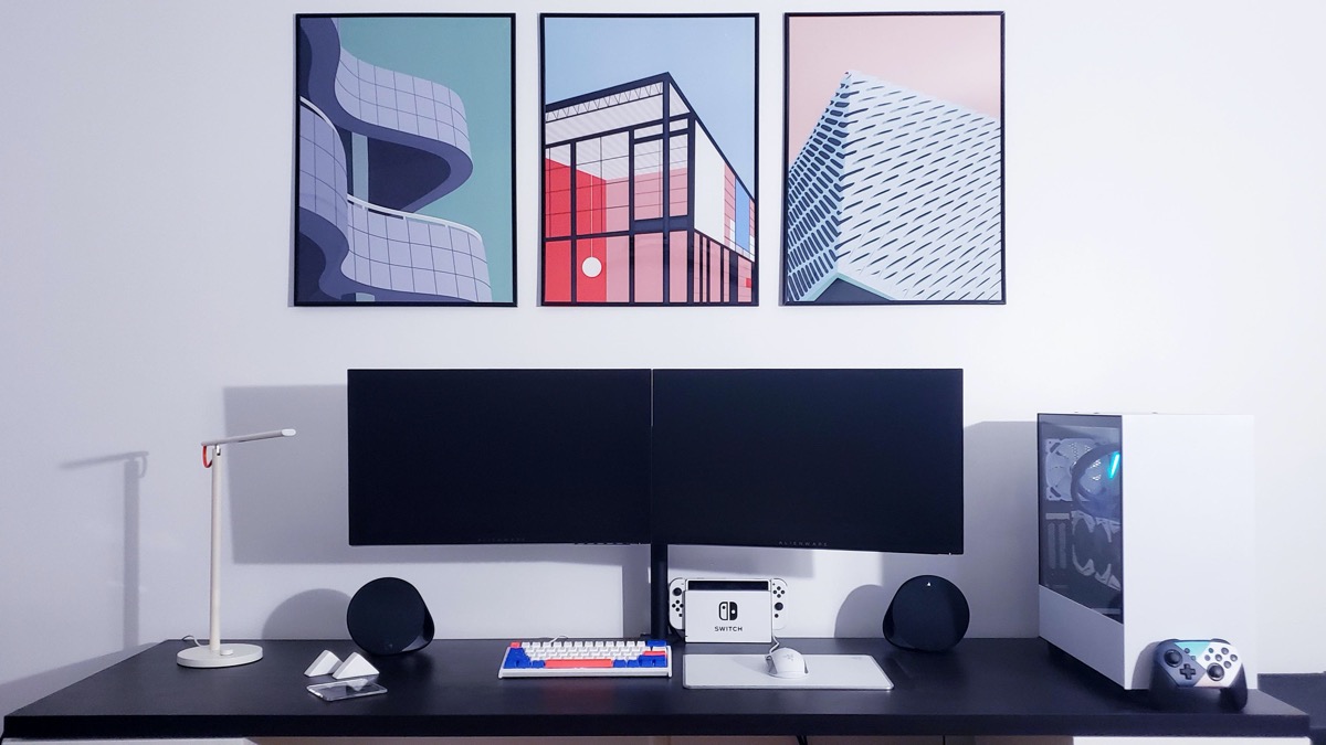 Bàn phím đầy màu sắc kết hợp ăn ý với bức tường trưng bày các bản in nghệ thuật kiến ​​trúc tạo hiệu ứng thẩm mỹ hút mắt cho phòng chơi game.