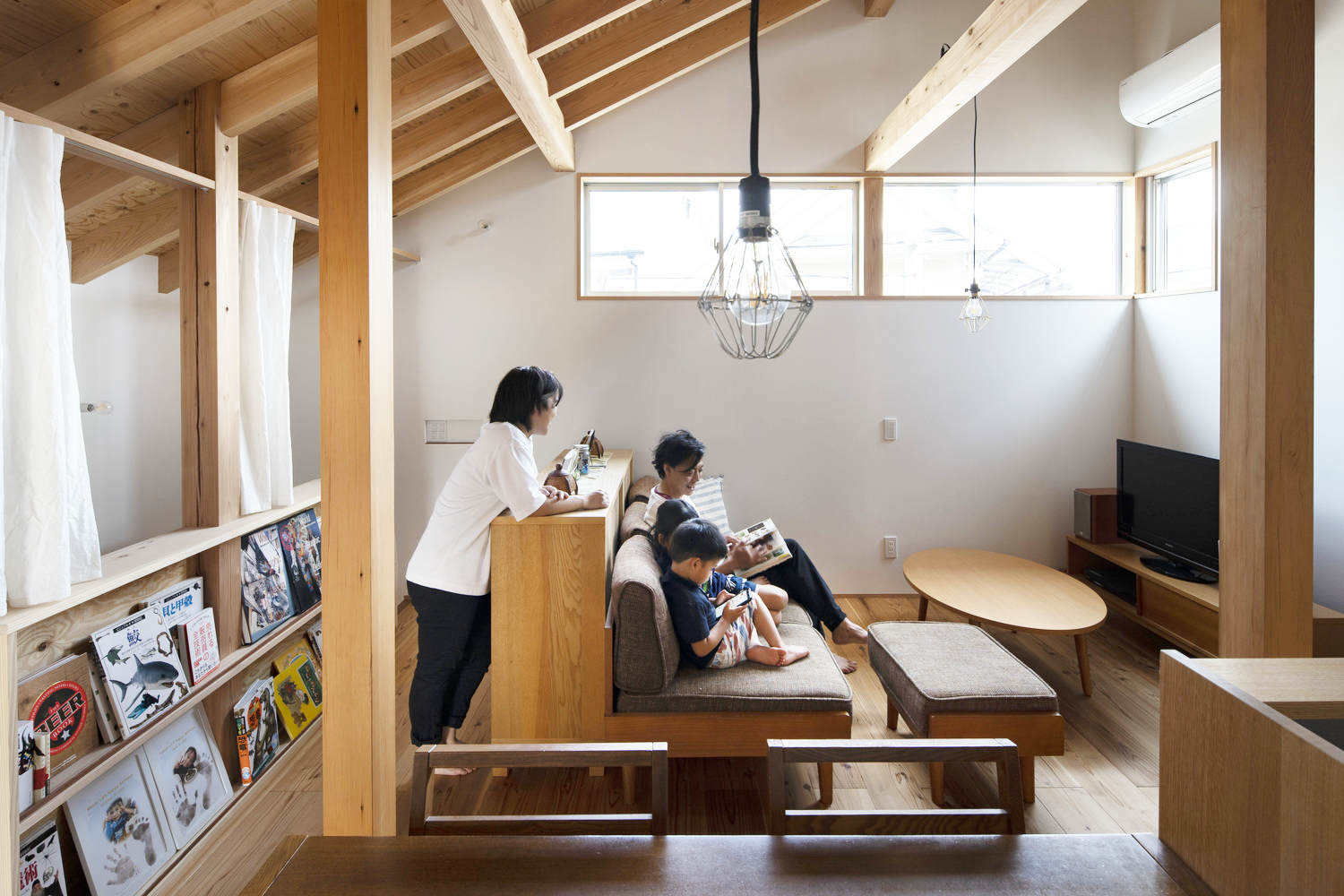 phòng khách ngôi nhà kiểu Nhật với cả gia đình bố mẹ, con cái quây quần trò chuyện, đọc sách
