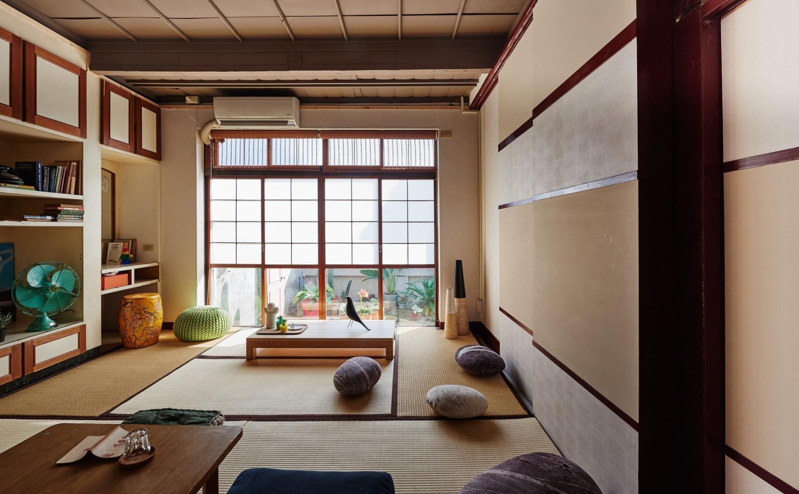 phòng khách kiểu Nhật với cửa sổ kính lớn, giá kệ gắn tường
